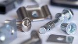 Verschiedene Metallbefestigungen wie Schrauben, Bolzen und Klemmelemente auf einer Oberfläche